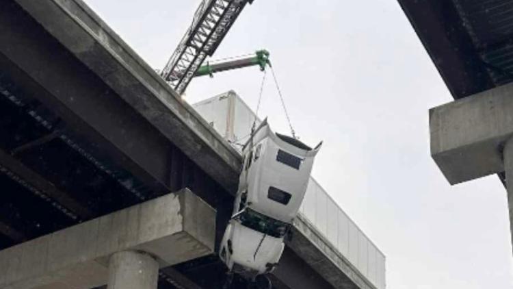 Batı Virginia’da buzlanma nedeniyle köprüden sarkan TIR’da kurtarılan sürücü, tuğla yüklü römork sayesinde hayatta kaldı